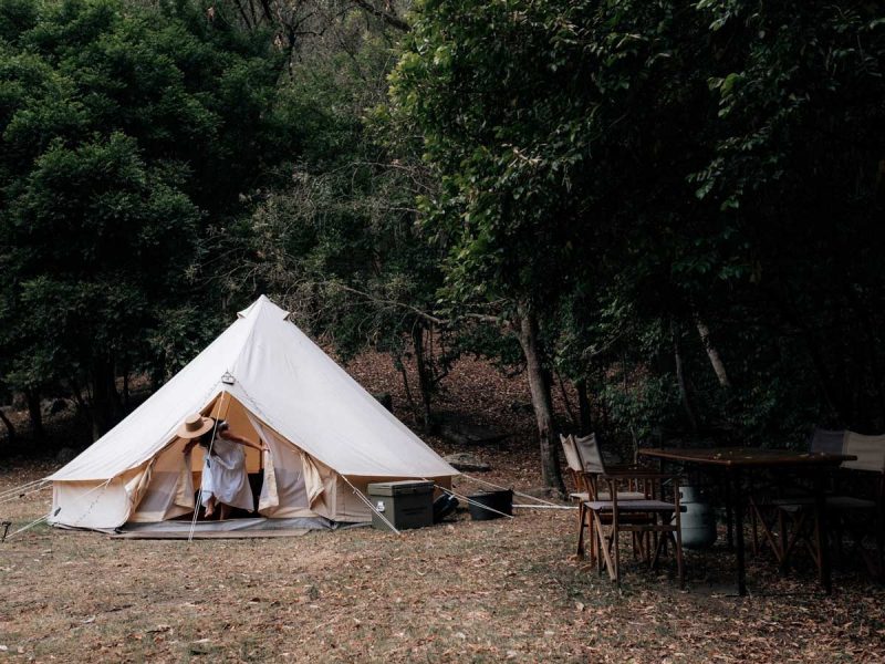 A woman coming out of a tent in the Glenworth Valley camping grounds in Central Coast, Australia