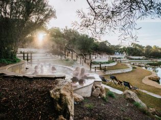 A group of people enjoy the Peninsula Hot Springs thermal baths in Victoria. (Image: Peninsula Hot Springs)