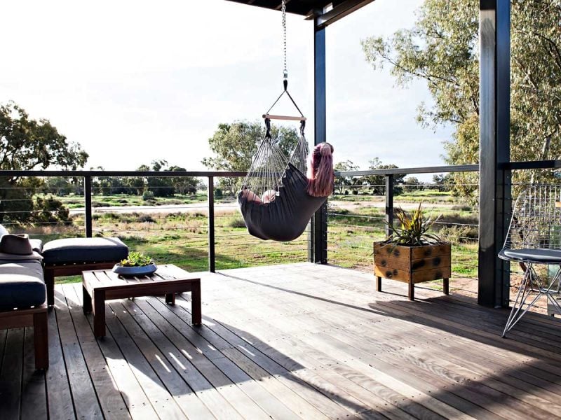 Woman sitting in a swing hammock in Callubri Station, NSW, Australi